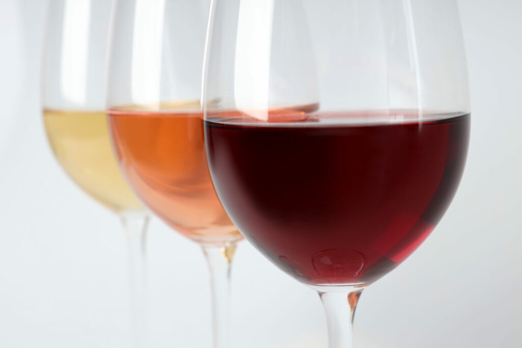Trois verres de vin en perspective. Rouge, rosé, blanc.